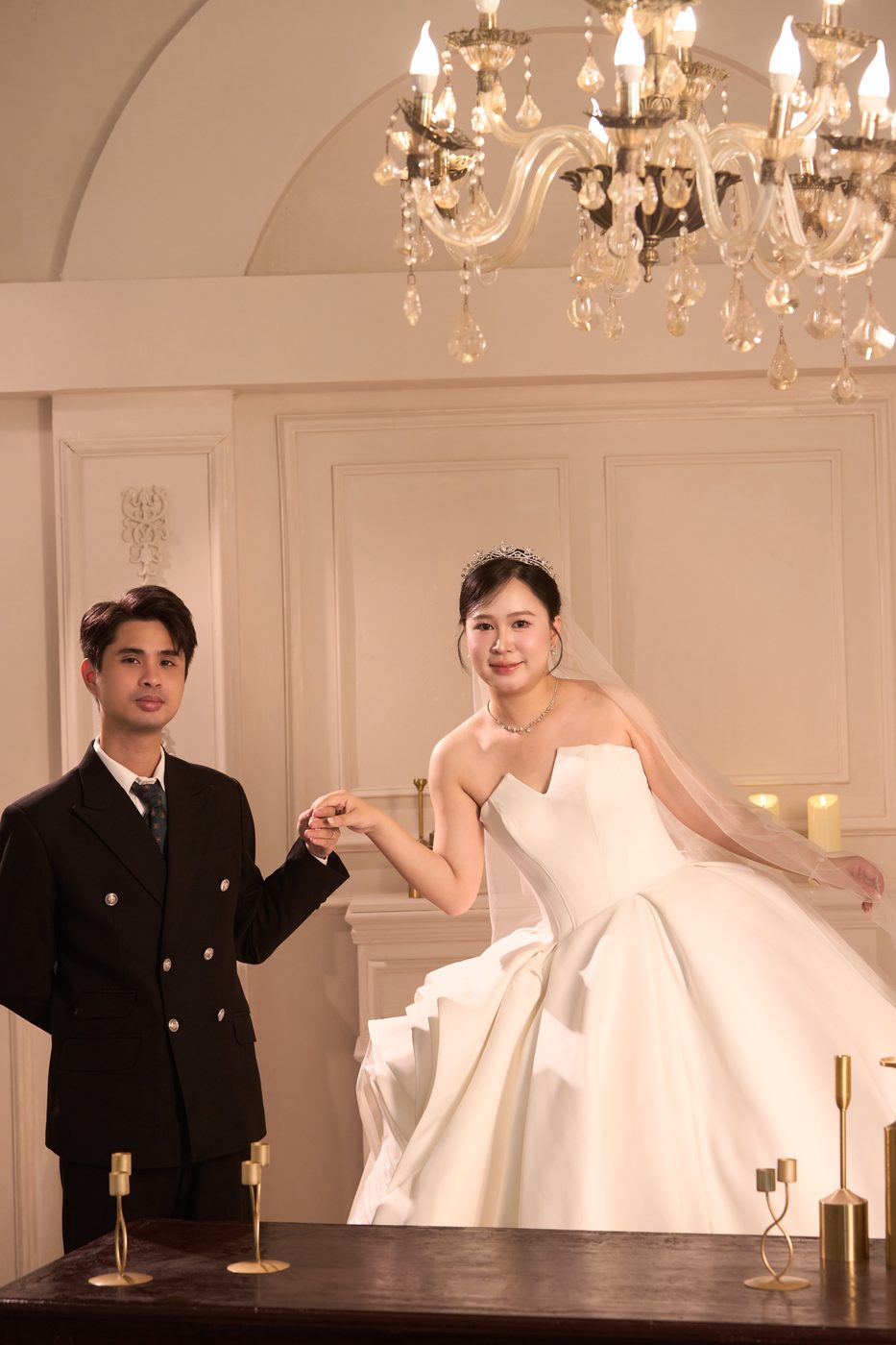 Cô dâu chú rể nắm tay trong phòng cưới
